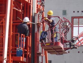 Építőipari munkások munkaruhában.